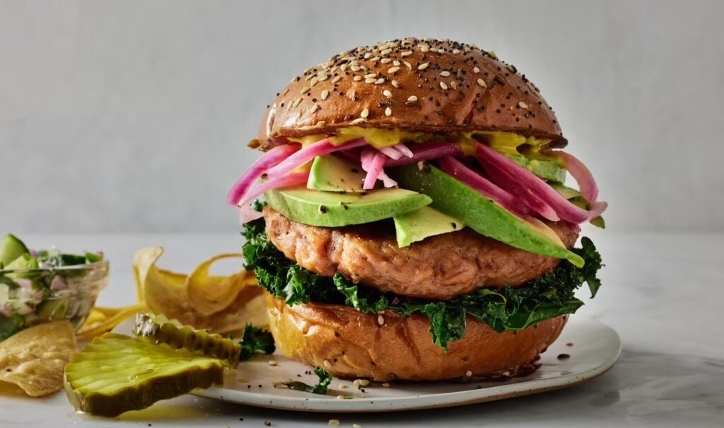 A vegan good catch salmon burger with lettuce, pickles and other toppings