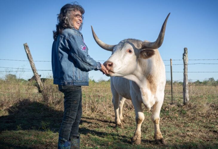 Renee King-Sonnen with a cow at Rowdy Girl vegan animal rescue sanctuary in Texas